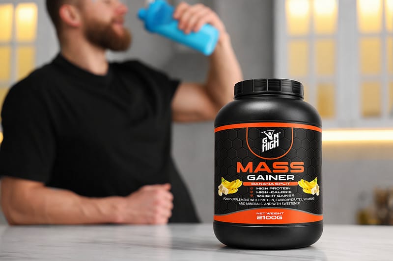 Young man with shaker of protein at white marble table in kitchen, focus on jar of powder